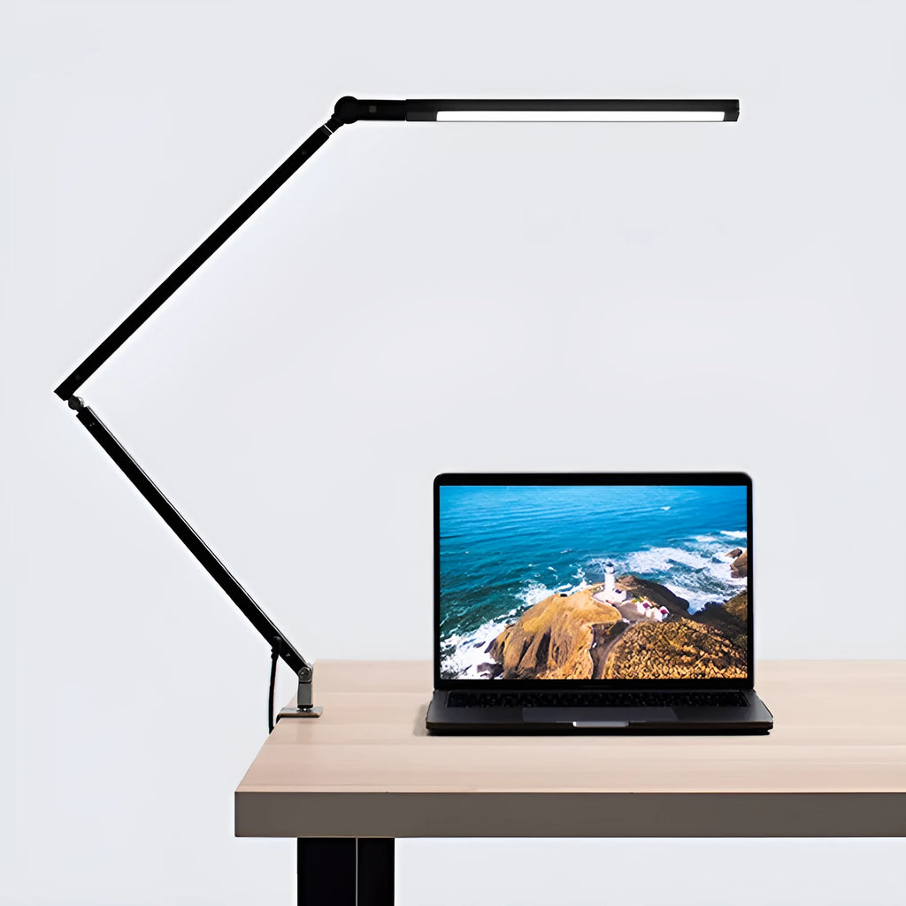 Aluminium LED desk lamp with clip base and remote control on a wooden desk.