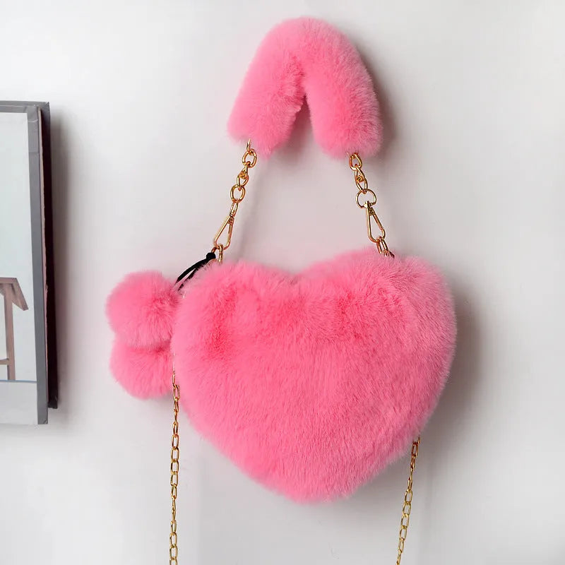 Soft plush heart-shaped women's handbag in a solid colour with a detachable shoulder strap.