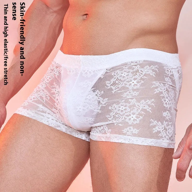 Men's black boxer briefs with white lace trim detail on a grey background.