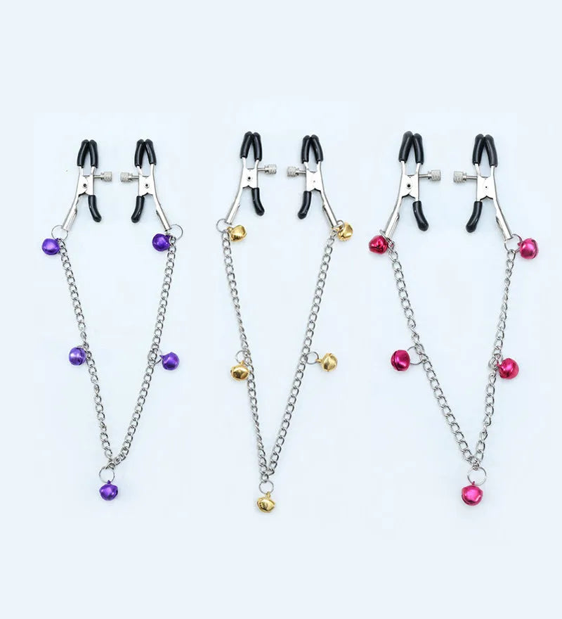 Red bell nipple clamp pair with chain attachment on a dark background