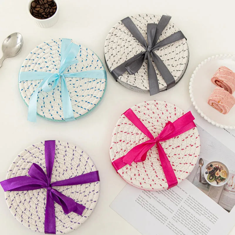 Set of three round grey cotton cord coasters, each 18cm in diameter, on a wooden table.