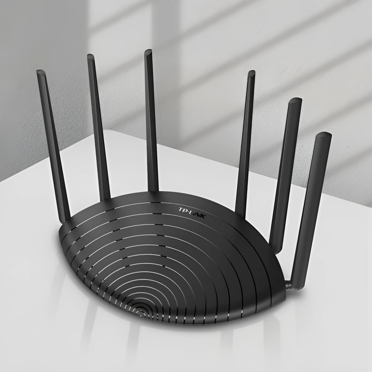 TP-Link TL-WDR7661 black AC1900 gigabit wireless router with antennas on a desk.