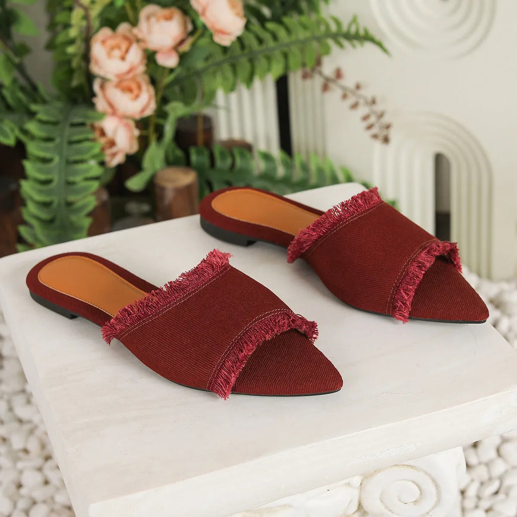 Women's flat denim slippers with a tassel detail, shown in apricot colour.