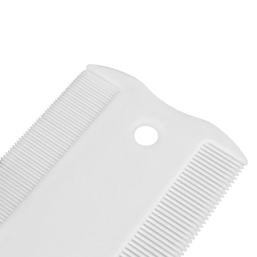 Small white plastic flea comb for pets with double-sided dense teeth, shown next to a ruler for scale.