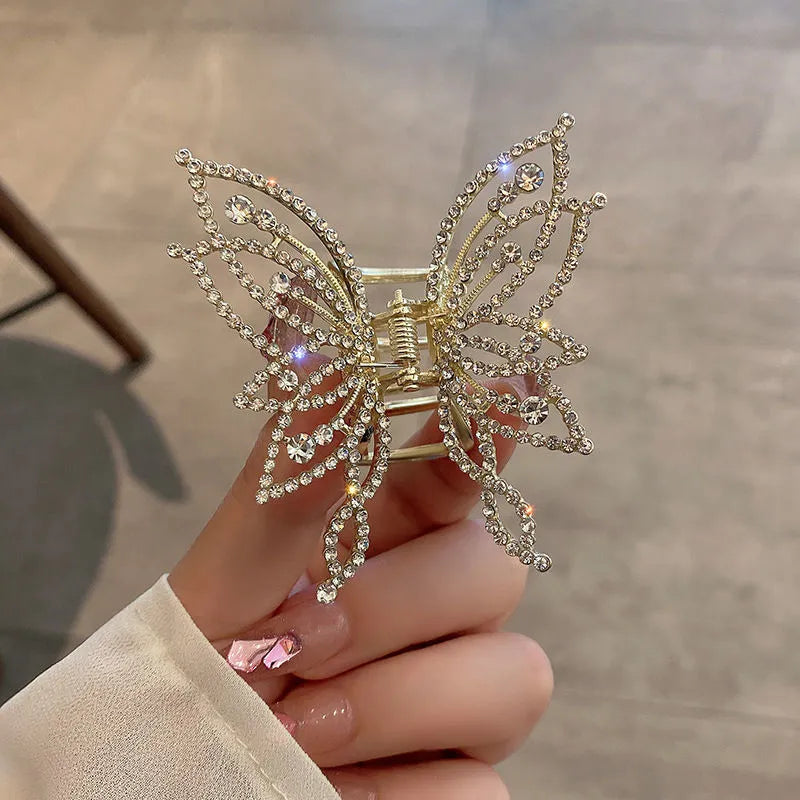 Butterfly-shaped alloy hair clip with electroplated finish in pearl or rhinestone style.
