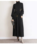 Loose turtleneck knit dress for women with long sleeves, elastic waist, and a big hem in a solid colour.