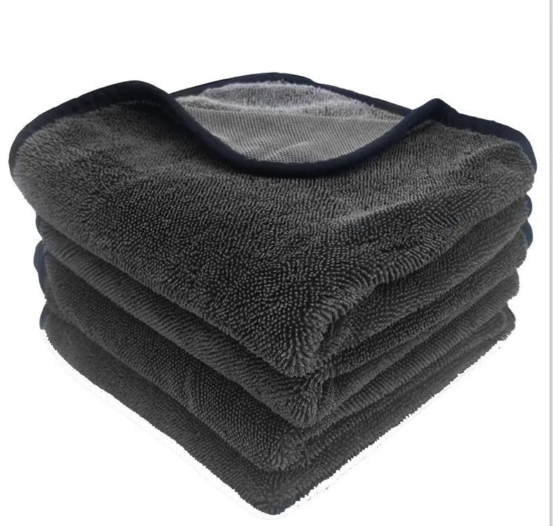 Grey automobile cleaning cloth with black edging showing spiral hair texture and hemmed edges