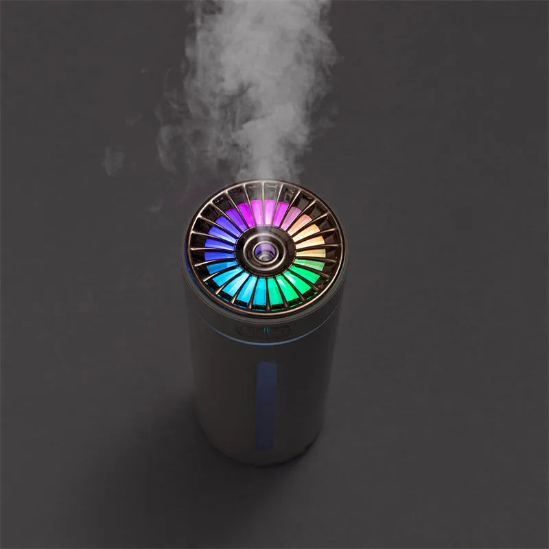 Black portable car humidifier with colourful LED lights showing mist output, placed in vehicle cup holder