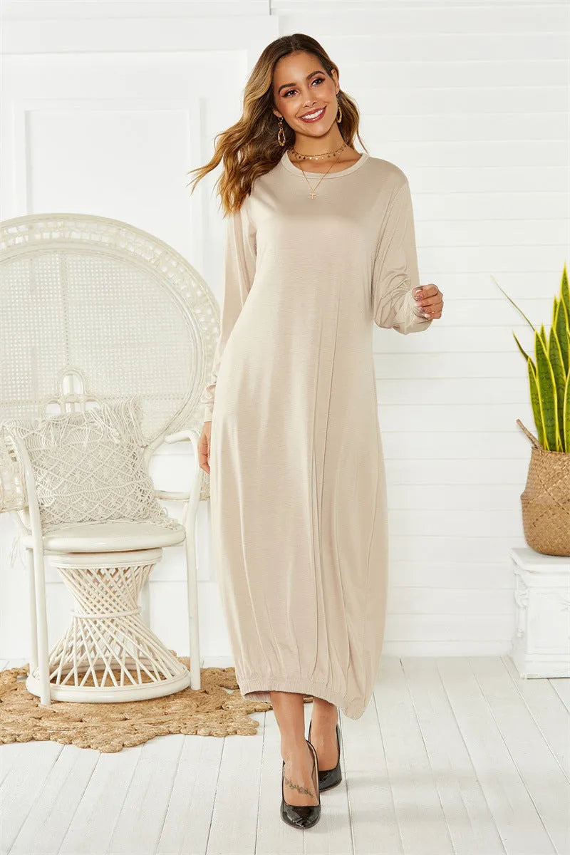 Loose black lantern dress with lace-up crew neck and long sleeves, laid flat.