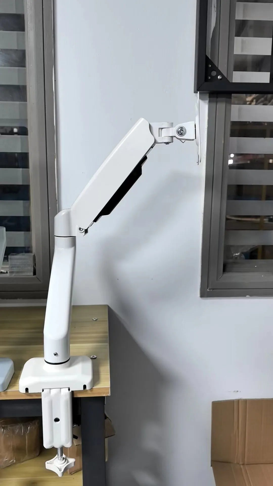 Black rotating telescopic LCD screen bracket on table with elevated display