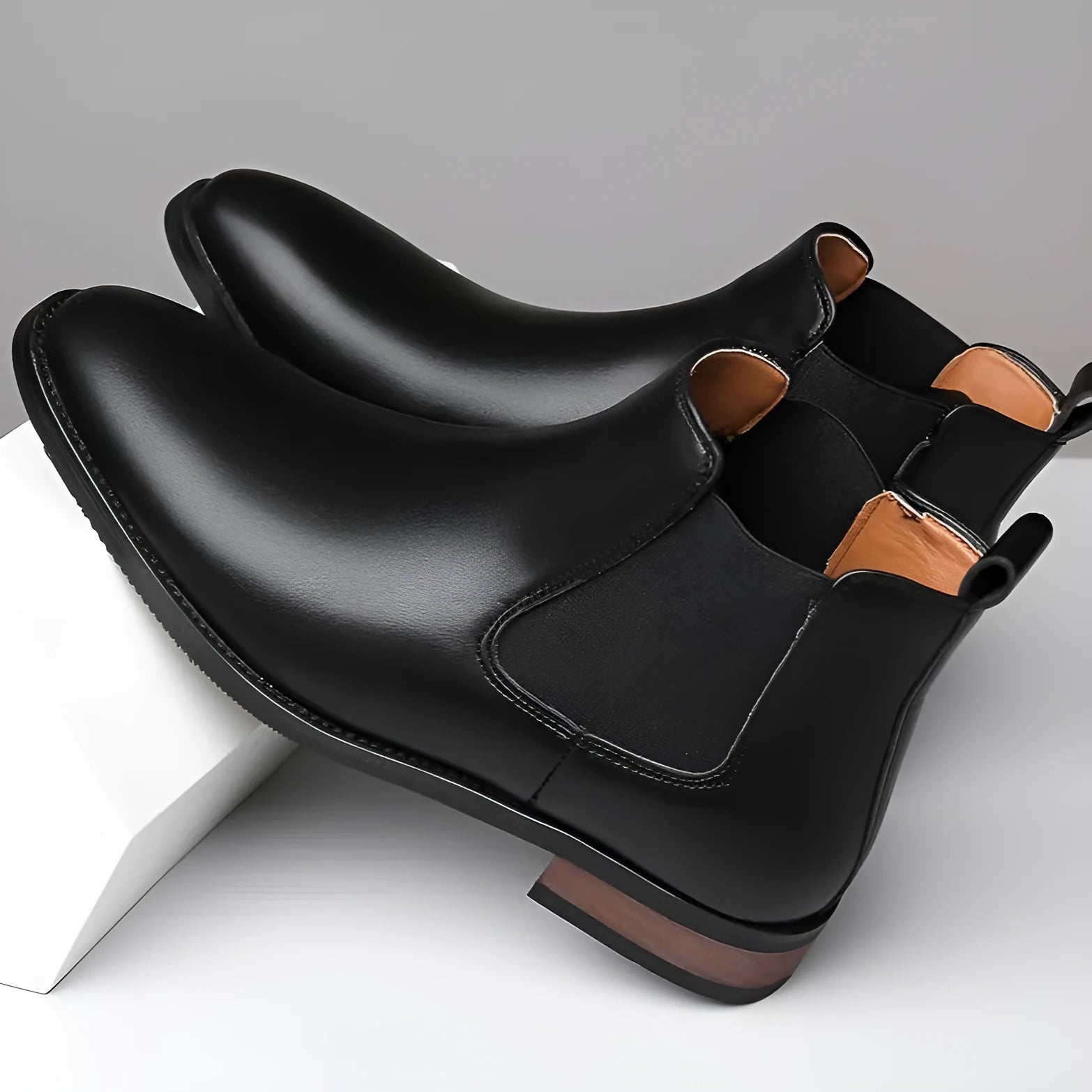 Men's black Chelsea boots with pointed toe design and decorative stitching