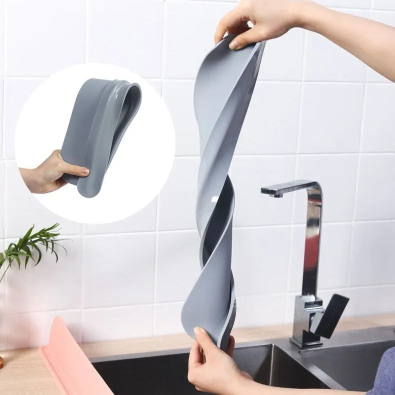 Grey silicone sink water blocking plate placed behind a kitchen tap