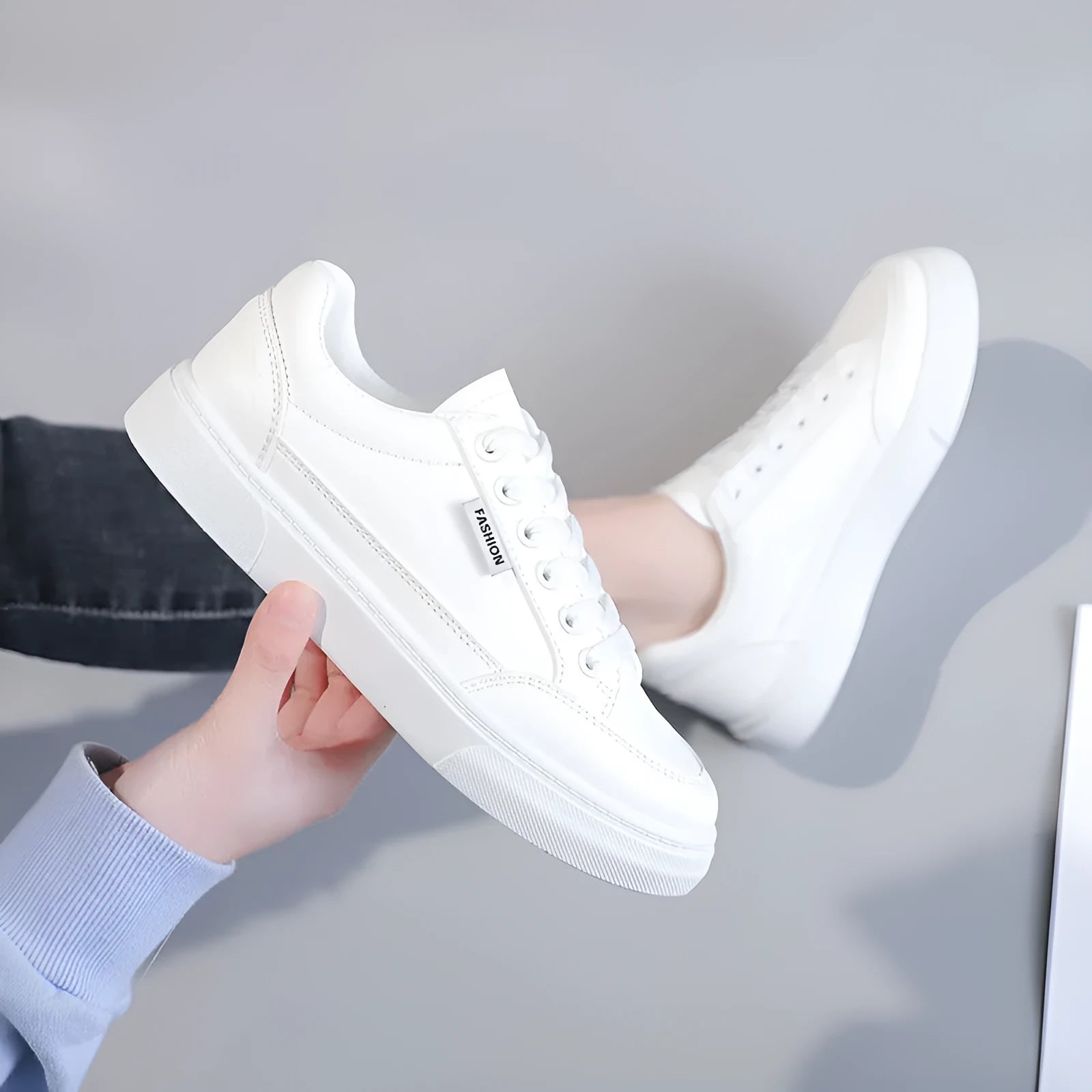 Korean style white low top PU sneakers for women on a plain background