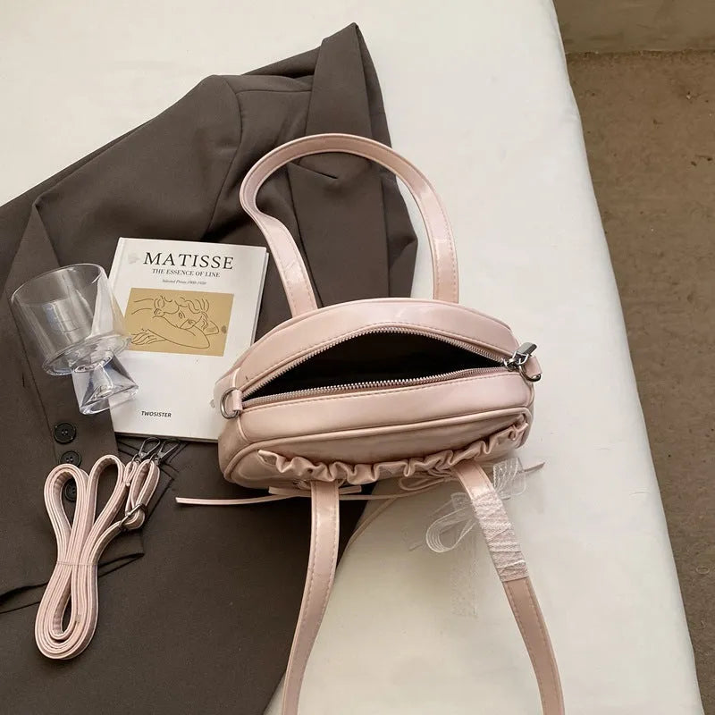 Women's casual shoulder bag in PU leather with a white bandage bow design on the front.