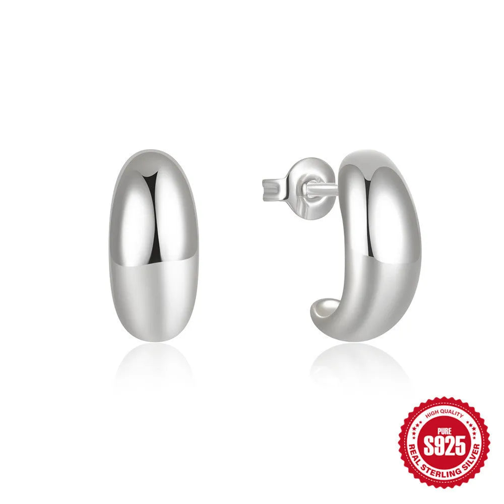 A single glossy C-shaped sterling silver stud earring on a plain background, showing gold and silver finish options.