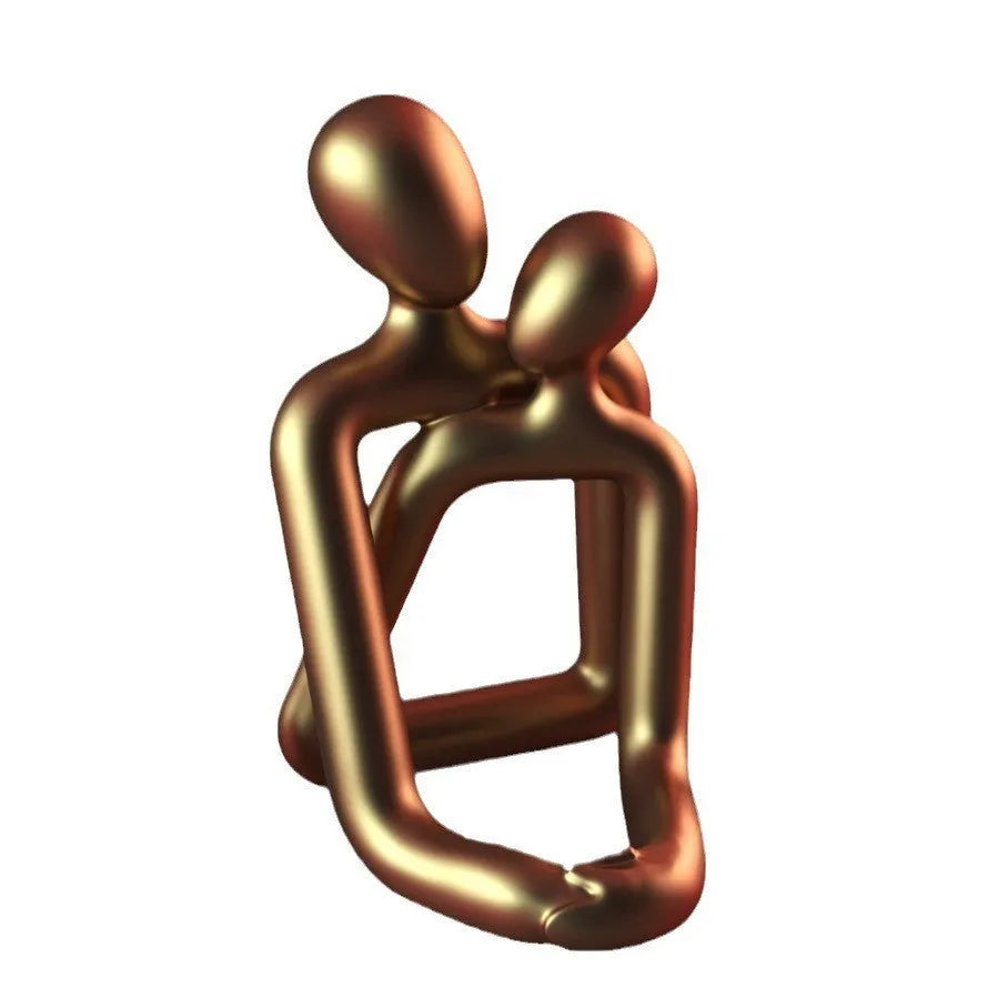 Modern minimalist loving couple resin statue in milky white or gold finish on a desk.